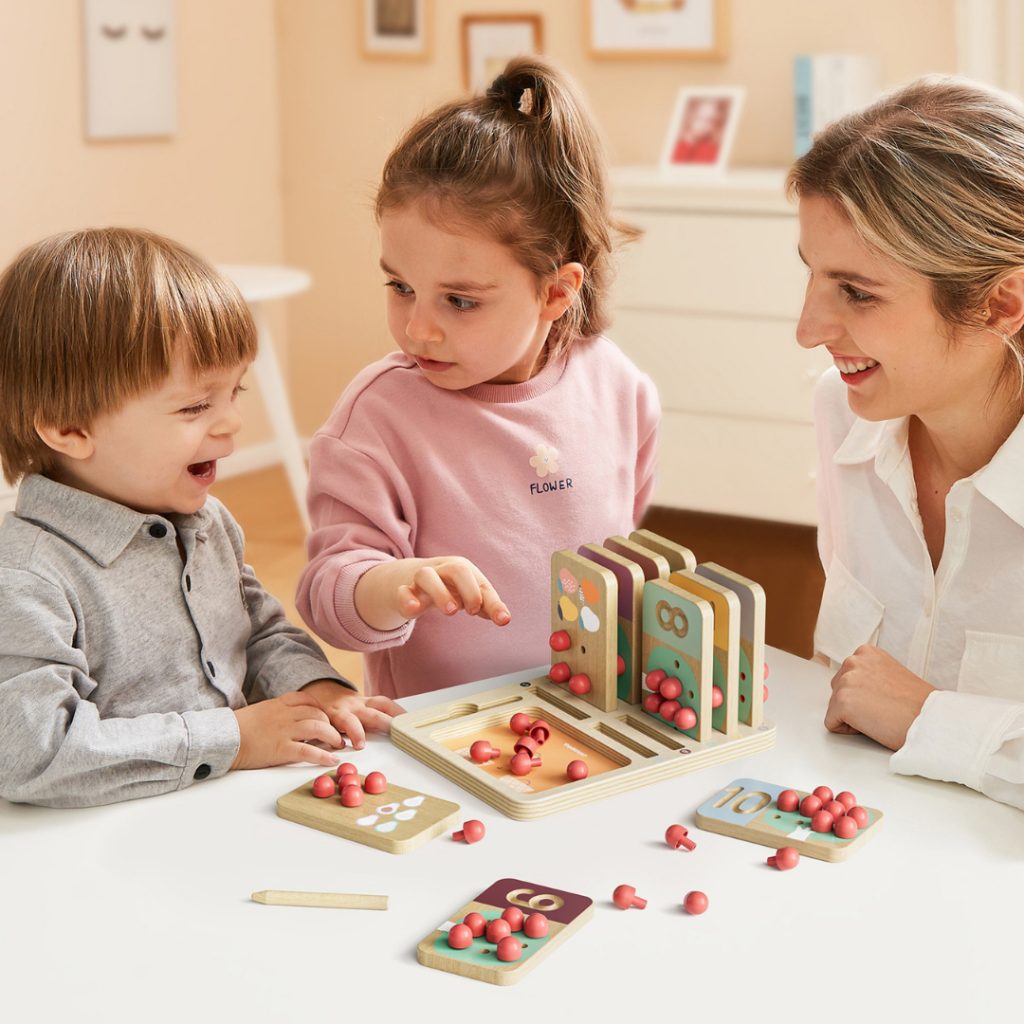Dzieci bawiące się zabawką edukacyjną z liczbami i kolorowymi kulkami. Zabawki dla dzieci wspierające rozw&oacute;j - Baby&Travel.